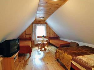 a attic room with a bed and a television at Dunia - Dom na wyłączność in Kazimierz Dolny