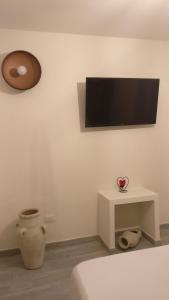 Habitación con TV de pantalla plana en la pared en Tresca Vecchia, en Bari