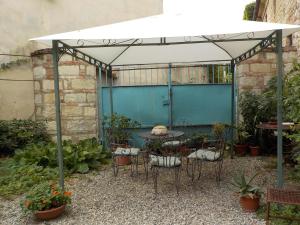 a patio with a table and chairs under a white canopy at Benvenuti Altrove in Cella Monte