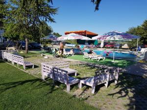 a row of benches next to a pool with umbrellas at DSK Hotel in Kranevo