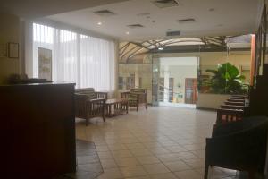 a dining room with tables and chairs and a lobby at Wawa's Golf View Inn in Taiping