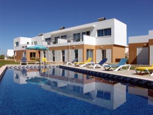 a house with a swimming pool in front of a house at Apartamentos Maritur in Albufeira