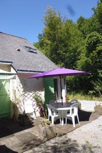 ラ・シャペル・シュル・エルドルにあるLe Pré de la Landeのパティオ(紫の傘付きのテーブルと椅子付)