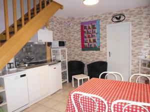 uma cozinha e sala de jantar com uma mesa com uma toalha de mesa vermelha em Le Pré de la Lande em La Chapelle-sur-Erdre