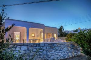 a house with a stone wall in front at Villa Evilia in Márpissa