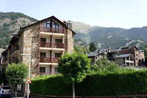 um edifício com uma árvore em frente em Hotel La Planada em Ordino