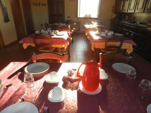 un restaurante con mesas de madera y un hervidor de té rojo en La Campagna Di Assignano, en Collazzone