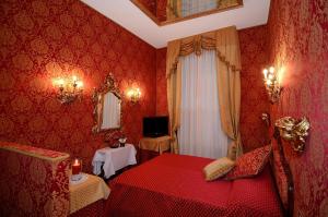 ein rotes Schlafzimmer mit einem Bett und einem Spiegel in der Unterkunft Residenza Bistrot De Venise in Venedig