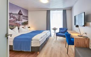 una habitación de hotel con una cama y un escritorio en Hotel Central Luzern, en Lucerna