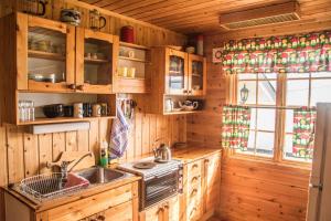 a kitchen with wooden cabinets and a sink and a stove at Seljenes Cottage in Russenes