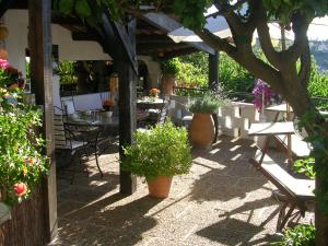 eine Außenterrasse mit Tischen, Stühlen und Pflanzen in der Unterkunft Chambres d'hôtes Les Terrasses du Soleil in Cagnes-sur-Mer