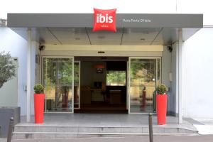 una puerta delantera de un edificio con un cartel en ibis Paris Porte d'Italie en Gentilly