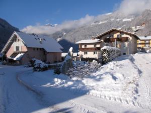 a house in the snow in front of a mountain at Apartmenthaus Kometerhof in Flattach