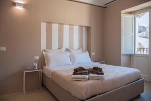 a bedroom with a bed with two towels on it at Kalote' On The Roof Apartments in Noto