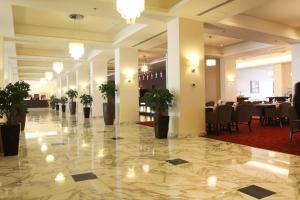 安曼的住宿－大皇宮酒店，大堂的地板上摆放着桌子和盆栽植物