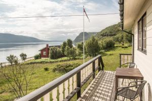 porche con banco y vistas al agua en Seljenes Cottage, en Russenes