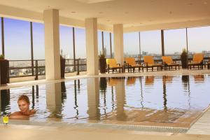 a man in a swimming pool at a hotel at Grand Palace Hotel in Amman