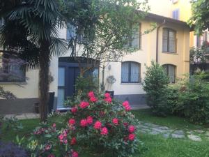 een huis met roze bloemen ervoor bij Elite Milano Apartments in Milaan