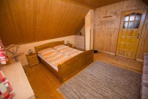 1 dormitorio con 1 cama en una habitación de madera en Chata Beňušovce, en Liptovský Trnovec