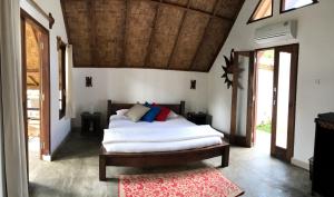 a bedroom with a bed and a wooden ceiling at Villa Paradise - Bukit Lawang in Bukit Lawang +36 photos