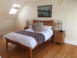 a bedroom with a bed and a wooden floor at Burrowlodge in Kilfenora