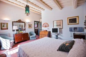 a bedroom with a bed and a desk and a television at Baglio Sant'Andrea in Valderice