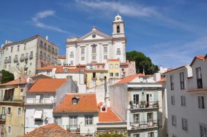 um grande edifício branco com uma torre de relógio em uma cidade em Alfama Cozy Loft em Lisboa