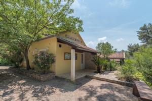 a small yellow building with trees in front of it at Villas Oleandri in Vrboska