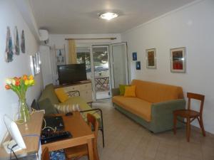 uma sala de estar com um sofá e uma televisão em Seaside Apartment em Tessalônica