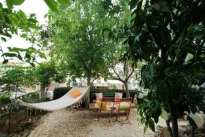 a hammock and chairs in a garden with trees at Villa Ivona in Makarska