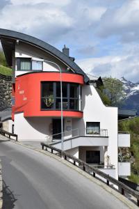 una casa en una colina con un techo rojo en La Mezza Luna, en Kappl