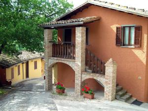 ein Haus mit einem Balkon und Blumen davor in der Unterkunft Agriturismo Orsaiola in Urbania