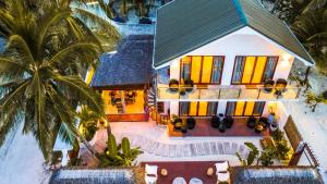 an aerial view of a house with palm trees at Veli Vilaa Dhiffushi - Beachfront in Dhiffushi