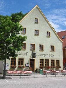 un gran edificio blanco con un árbol delante en Gasthof Schwarzer Bär, en Kastl