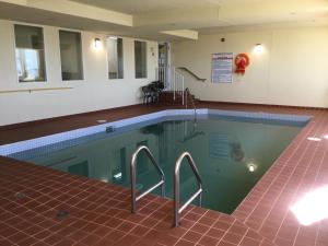 a swimming pool with stairs in a building at Western Budget Motel #1 Grande Prairie in Grande Prairie