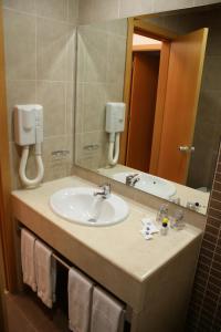 a bathroom with a sink and a mirror at Hotel O Novo Principe in Almeirim