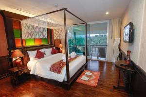 una camera da letto con letto a baldacchino e balcone di Mountain Creek Wellness Resort Chiangmai a Chiang Mai Altre 97 foto