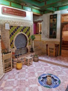 非斯的住宿－博物館之家- 達美亞尼酒店，客房设有壁炉、桌子和椅子。