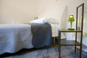1 dormitorio con 1 cama y 1 mesa con lámpara en La casetta dei racconti, en Bovino