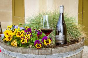 eine Flasche Wein und ein Glas Blumen in der Unterkunft Bahnhof Busch in Bretzfeld