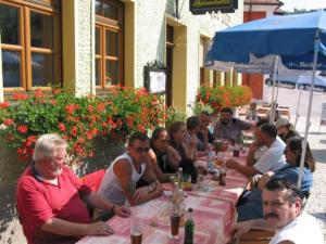 grupa ludzi siedzących przy długim stole w obiekcie Gasthof Schwarzer Bär w mieście Kastl