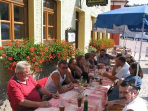 Un groupe de personnes assises à une longue table dans l'établissement Gasthof Schwarzer Bär, à Kastl