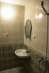 a bathroom with a sink and a shower with a mirror at Guest House Jumbo in Aheloy