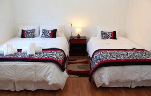two beds sitting in a room with at Hostal del Centro Concepción in Concepción