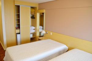 a bedroom with two beds and a closet at Hotel Atlantico Rio Grande in Rio Grande