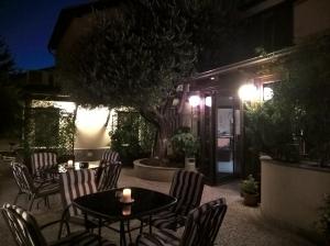 a patio with a table and chairs at night at Hotel Rocco in Carugate