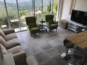 a living room with a couch and chairs and a television at Dieu L'Amour - Molinard in Châteauneuf