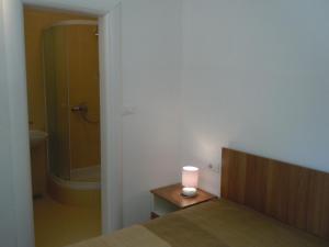 ein Schlafzimmer mit einem Bett und einer Kerze auf einem Tisch in der Unterkunft Apartments Tri sestrice in Sveta Nedelja