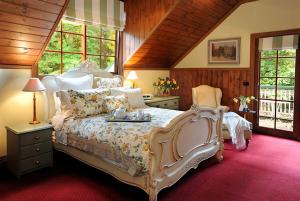 ein Schlafzimmer mit einem großen Bett in einem Zimmer mit Fenstern in der Unterkunft Mary Cards Coach House in Olinda