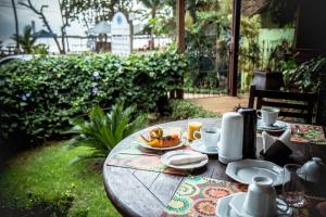 a wooden table with a plate of food on it at Porto dos Casais Guest House Itacaré in Itacaré